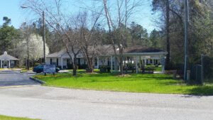 A one story apartment building with trees and green grass