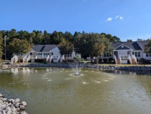 A one story apartment community with a pond