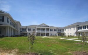 A white large two story building with green grass