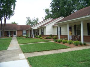 A one story apartment building with green grass and sidewalks