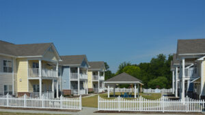 A group of four apartment buildings that have a gazebo in the center