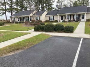 A one story apartment building bushes