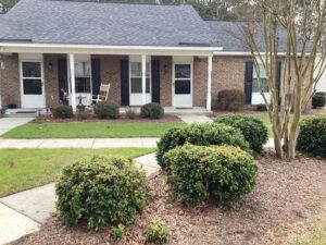 A one story apartment building with bushes