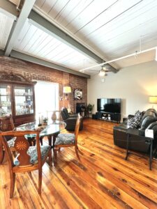 Living room with brick wall, hardwoods and large window