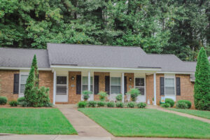 A brick one story building with a green lawn.
