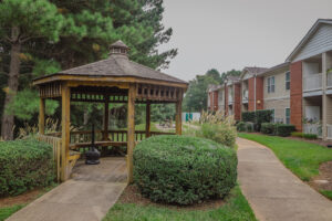 A wooden gazebo at a two story apartment building