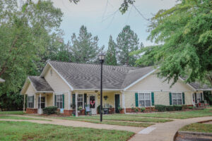 A one story apartment building with green grass and a sidewalk