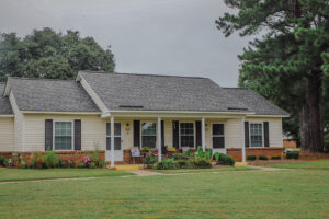 A one story townhome style building with green grass