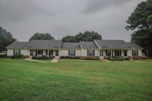 A one story apartment building with a large green lawn