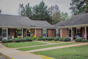 A brick one story apartment building with green grass