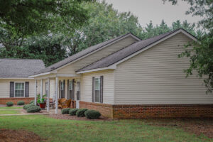 A one story townhome style apartment building with green grass