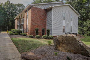 A two story apartment building with bushes