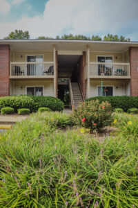 A two story apartment building with green landscaping