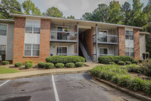 A two story apartment building with green bushes