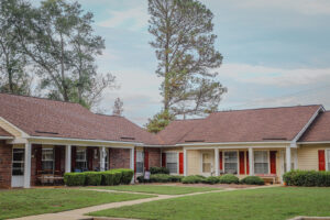 A one story apartment building with green grass and a blue sky