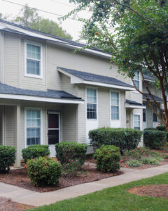 A two story apartment building with grey siding