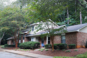 A two story apartment building with bushes