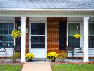 Single story apartment complex with yellow flowers