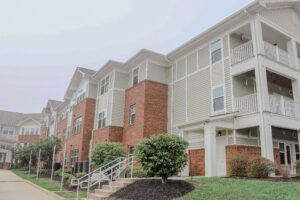 A three story apartment building with green landscaping