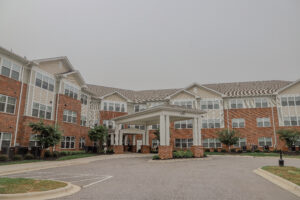 The front entrance of a three story apartment building with a covered entrance