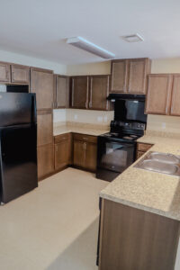 A kitchen with black appliances and wooden cabinets