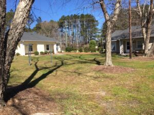 Two one story buildings with grass and trees