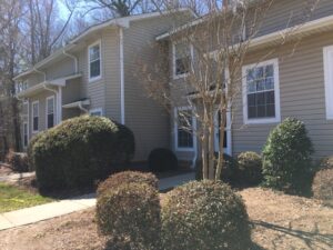 A two story apartment building with bushes