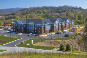 Ariel photo of apartment complex, trees and mountains