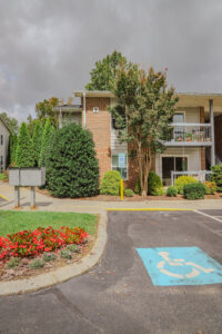 Two story apartment complex, landscaping and handicap parking spot