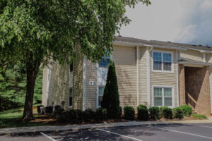 Two story apartment with mature trees and landscaping