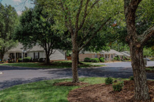 Single story apartment with mature trees and landscaping