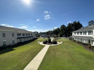 The inner garden lawn of a large two story apartment community on a sunny day