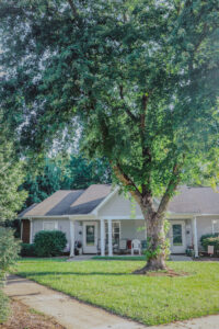 A one story building with a tree