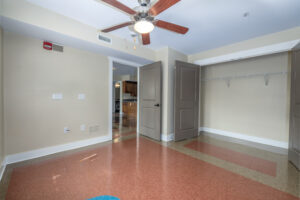 Large, sunlit room with ceiling fan and tile floor