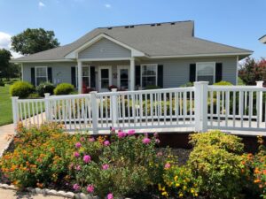 A one story apartment building featuring a ramp and spring landscaping