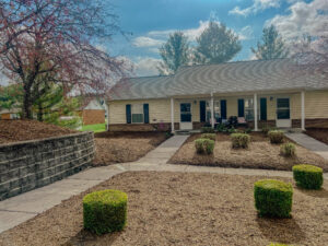 Single story apartment with front porch and landscaping