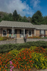 Single story apartment complex with front porch and flowers