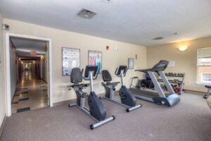 Workout room with stationary bike, treadmill and weights