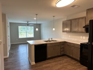 The kitchen of an apartment that is open to the living room