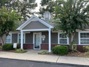 A one story apartment building. Brown with white trim