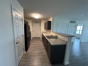 A galley kitchen with brown floors and cabinets