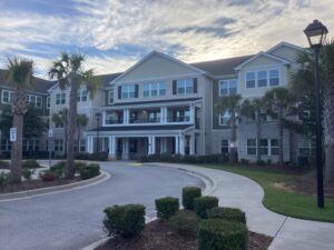 The outside of a three story apartment building with a a circle driveway