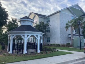 A gazebo outside of a three story apartment building