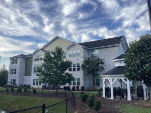 A three story apartment building with a gazebo and a blue sky