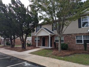 Two story apartment building with trees in frotn