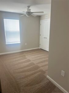 A bedroom with a ceiling fan