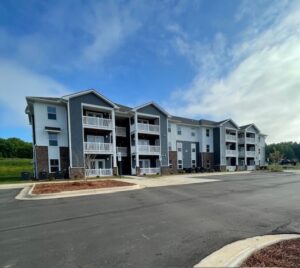 A three story apartment building with a blue sky