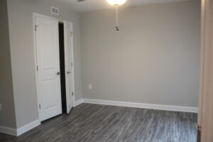 A bedroom with a closet and ceiling fan