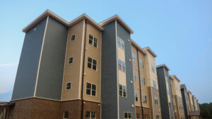 A four story apartment building with a blue sky