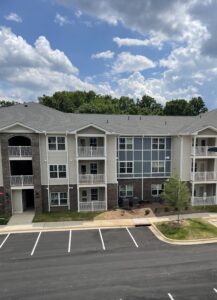 A three story apartment building with a sunny blue sky